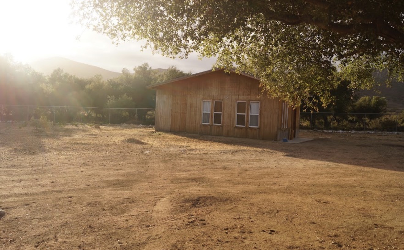 Cabaña rústica al atardecer entre las montañas